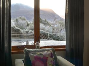 a window with a view of a snow covered mountain at Cushendall House in Torcastle