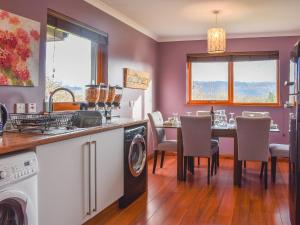 a kitchen and dining room with a table and a washer at Cushendall House in Torcastle +24 photos