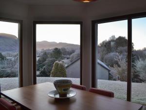 a coffee cup sitting on a table in front of windows at Cushendall House in Torcastle