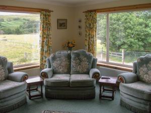 a living room with two chairs and a large window at Lower Brae in Achnahanat