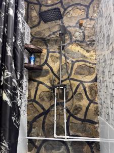 a stone wall with a shower in a bathroom at Artuch Camp - Fan Mountains in Yakkakhona +26 photos