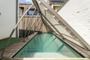 a swimming pool in a house with a wooden stairs at Barbara' s Guesthouse in Watou