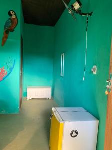 a room with a green wall with a cooler in it at Pousada Suíte Conexao in Conceição da Barra