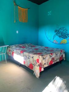 a bed in a room with a blue wall at Pousada Suíte Conexao in Conceição da Barra