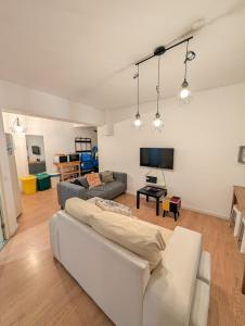 a living room with a white couch and a tv at Travel & Live Marques in Porto