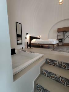 ein Schlafzimmer mit Bett, Badewanne und Spiegel in der Unterkunft Hotel Pietranera in Catania