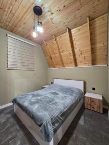 a bedroom with a bed and wooden ceilings at Villa ZM garden in Quba
