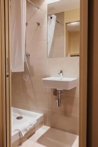 ein kleines Badezimmer mit Waschbecken und Dusche in der Unterkunft Hotel Astrid Caen centre in Caen