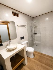 a bathroom with a toilet and a sink and a shower at Luling Guesthouse in Badung
