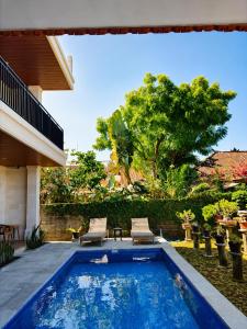 a swimming pool in the yard of a house at Luling Guesthouse in Badung