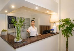 a woman standing at a counter in a room at Hotel Stella D'Italia in Viareggio