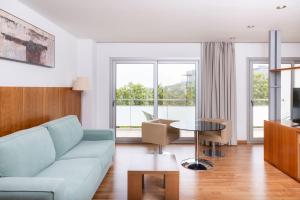 a living room with a blue couch and a table at RVHotels Nautic Park in Platja d'Aro