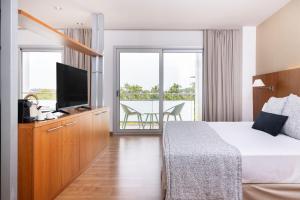 a hotel room with a bed and a flat screen tv at RVHotels Nautic Park in Platja d'Aro