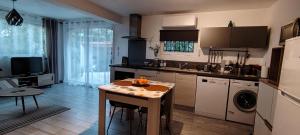 a kitchen with a table and a sink and a stove at Charmant studio à Castillon du Gard, à deux pas du Pont-du-Gard in Castillon-du-Gard