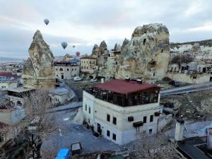 a group of hot air balloons flying over a city at Diamond of Cappadocia in Göreme