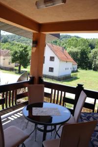 a balcony with a table and chairs and a white building at Apartman Anastasija in Guča