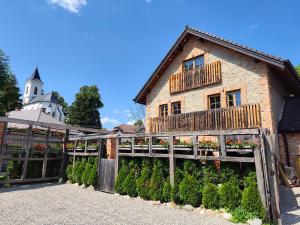 a building with a wooden fence and flowers at Liptov Lodge in Liptovský Mikuláš