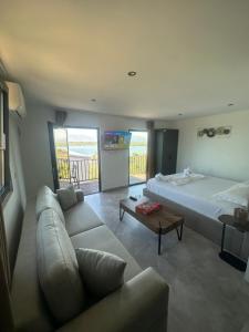 a living room with a bed and a couch at Lake Escape Villa Shirokë in Shkodër