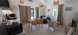 a kitchen and living room with a table and chairs at Le gîte de Coline in La Bridoire