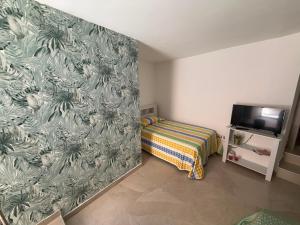 a bedroom with a bed and a wall with a wallpaper at B&B "Arberia"casa vacanze in San Giorgio Albanese
