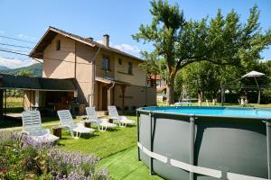 a backyard with a pool and chairs and a house at Вила Якимови in Ribarica