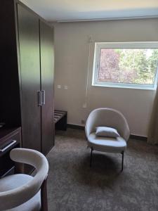 a room with two chairs and a chair and a window at Les Portes d'Apcher in Saint-Chély-dʼApcher +29 photos