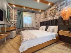 a bedroom with a large bed and a brick wall at Qara Otel in Ayvalık