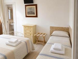 a bedroom with two beds and a sink at Marea Blanca - Rooms & Garden in Torre Lapillo