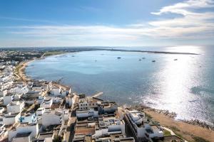 an aerial view of a beach with houses and the water at Marea Blanca - Rooms & Garden in Torre Lapillo