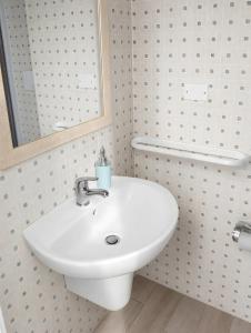 a bathroom with a white sink and a mirror at Marea Blanca - Rooms & Garden in Torre Lapillo