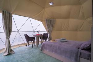 a bedroom with a bed and a table in a tent at Nomad Space in Bar-Bulak +16 photos
