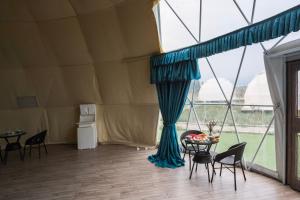 a room with a tent with a table and chairs at Nomad Space in Bar-Bulak