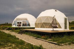 two domes in a field under a cloudy sky at Nomad Space in Bar-Bulak