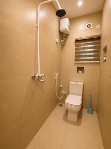 a bathroom with a toilet and a shower at Westside Beach Resort & Hotel in Mopo Akinlade +5 photos