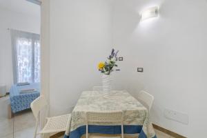 a dining room table with a vase of flowers on it at Maison Vivian Rooms in Marzamemi +27 photos