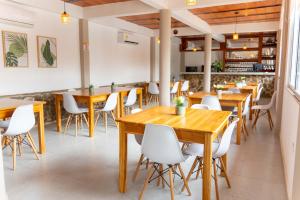 a restaurant with wooden tables and white chairs at Horizonte del Mar Hotel Boutique in Santa Marta