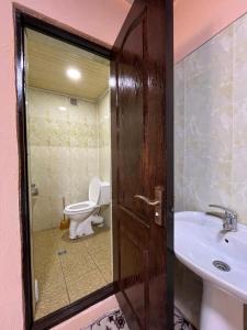 a bathroom with a toilet and a sink at Gostevoy dom Dovul in Chimgan