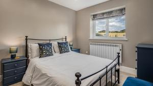 a bedroom with a bed and a window at Roe Barn in Sherston