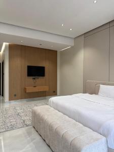 a bedroom with two beds and a flat screen tv at Al Reef Garden in Sohar