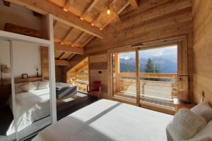 a bedroom with a bed and a large window at Chalet "Lucyvon" exceptional view in Manigod