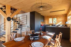 a dining room with a wooden table and a staircase at Chalet "Lucyvon" exceptional view in Manigod