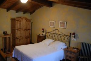RugandoにあるCasa Grande da Ferreria de Rugandoの白いベッドと木製キャビネット付きのベッドルーム1室が備わります。