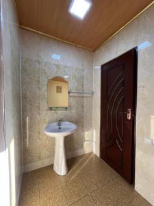 a bathroom with a sink and a brown door at Gostevoy dom Dovul in Chimgan