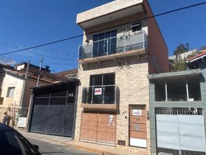a brick building with a balcony on a street at Hospedagem da Néli 2 in Aparecida