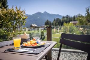 a table with a plate of fruit and a glass of orange juice at Hotel Wetterstein by keyone in Seefeld in Tirol +283 photos