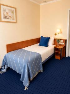 a hotel room with a bed with a blue blanket at Hotel Kreuzplatz Gießen Zentrum in Gießen +21 photos