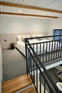 a white bedroom with a bed and a staircase at Gaia in Türkistan