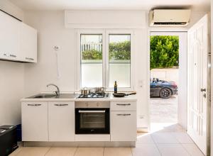 a white kitchen with a sink and a stove at Hotel Stella D'Italia in Viareggio