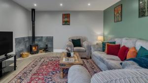 a living room with a couch and a fireplace at Roe Barn in Sherston