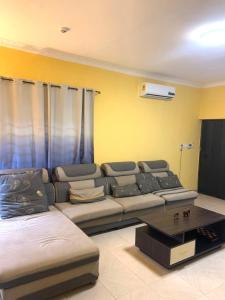 a living room with a couch and a table at Archelux Developments in Bawalishi +33 photos
